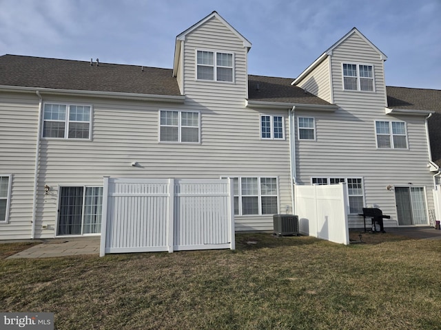 rear view of property with a yard, cooling unit, and a patio area