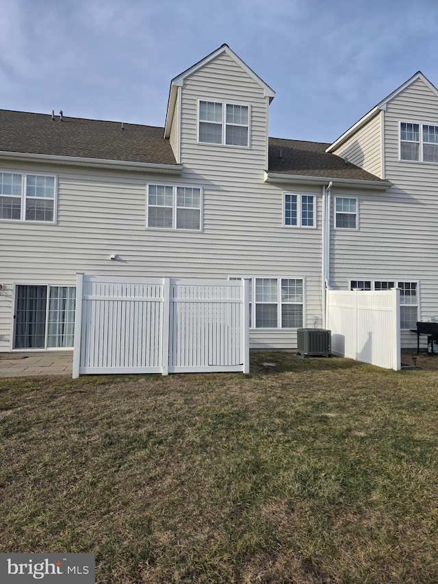 back of property featuring central AC and a yard