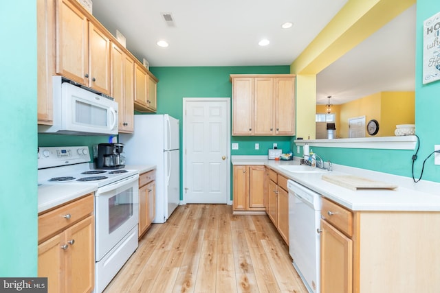 kitchen with light brown cabinetry, sink, light hardwood / wood-style floors, kitchen peninsula, and white appliances