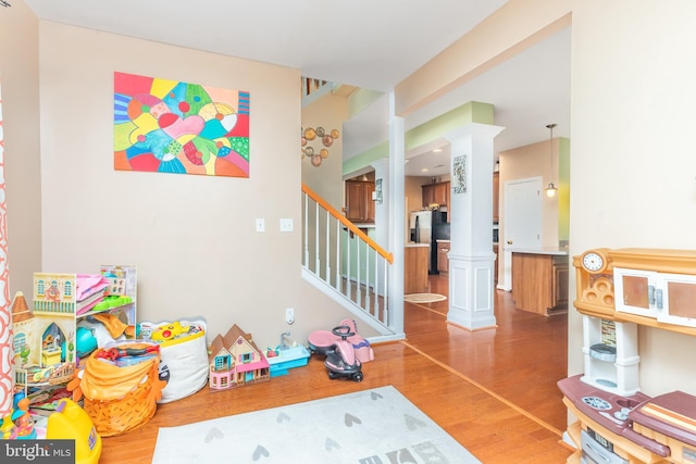 playroom with hardwood / wood-style flooring and ornate columns