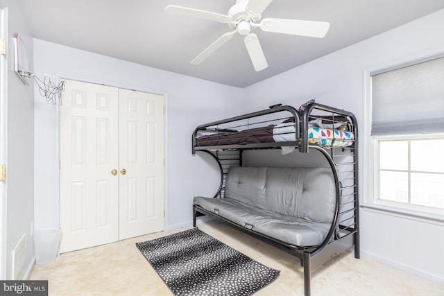 carpeted bedroom with a closet and ceiling fan