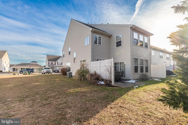 view of side of home with a yard and central AC unit