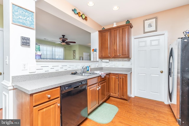 kitchen with sink, stainless steel fridge, dishwasher, light hardwood / wood-style floors, and decorative backsplash