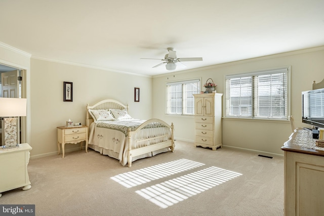 carpeted bedroom with ornamental molding and ceiling fan