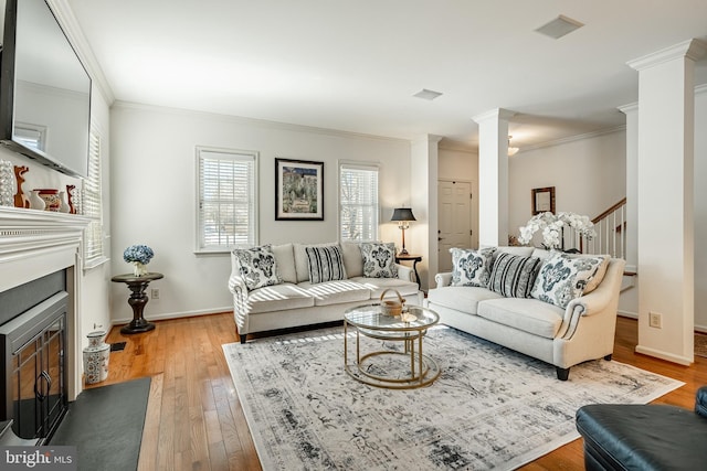 living room with ornamental molding, wood-type flooring, and ornate columns