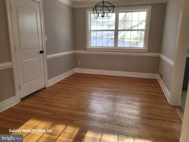 unfurnished dining area featuring hardwood / wood-style floors and a chandelier