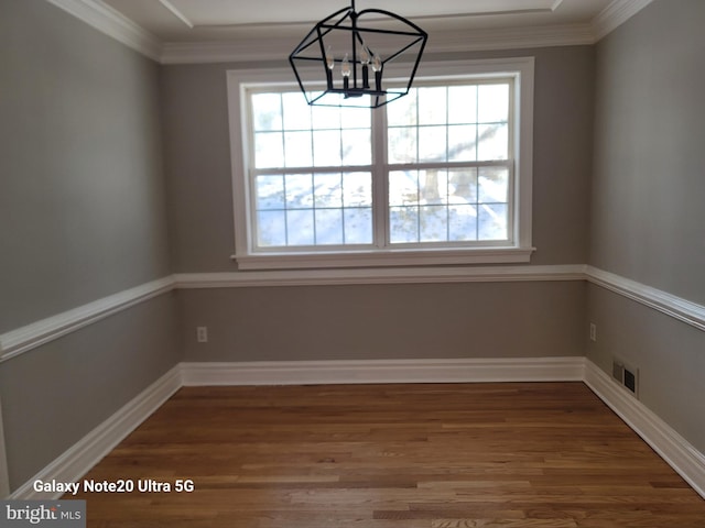 unfurnished dining area with dark hardwood / wood-style floors, a wealth of natural light, and a chandelier