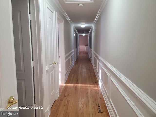 hall featuring ornamental molding and light wood-type flooring