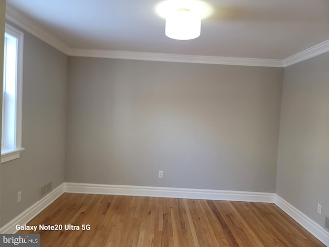 unfurnished room with crown molding and hardwood / wood-style flooring