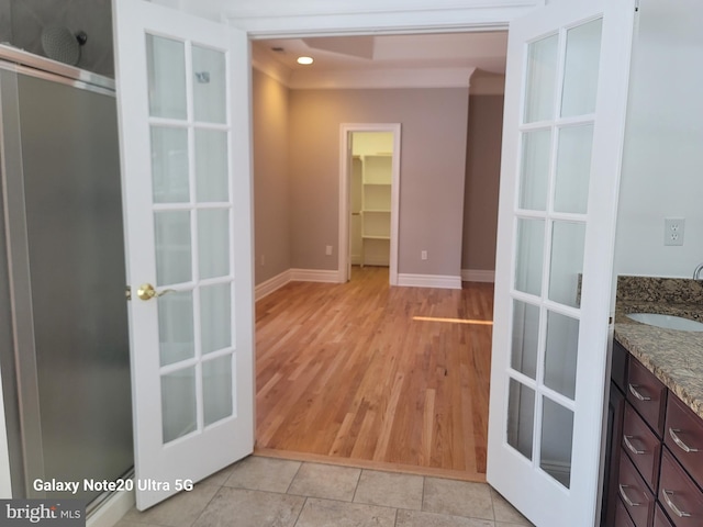 interior space with sink, light wood-type flooring, and french doors