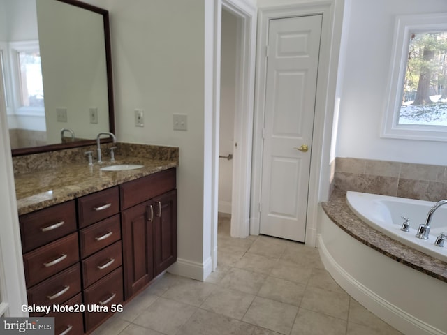 bathroom featuring tile patterned flooring, vanity, and a washtub