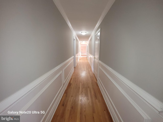 hall featuring crown molding and light hardwood / wood-style floors