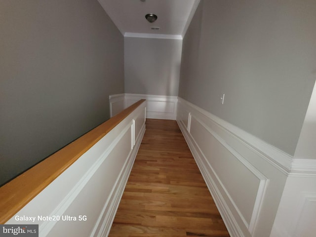 hall with crown molding and light hardwood / wood-style floors