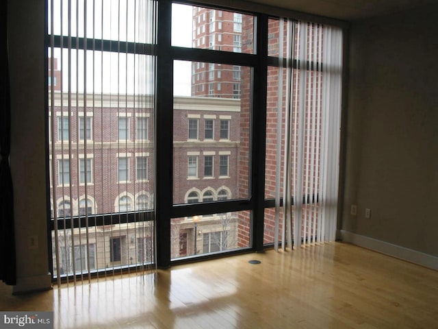 empty room featuring hardwood / wood-style floors and a wall of windows