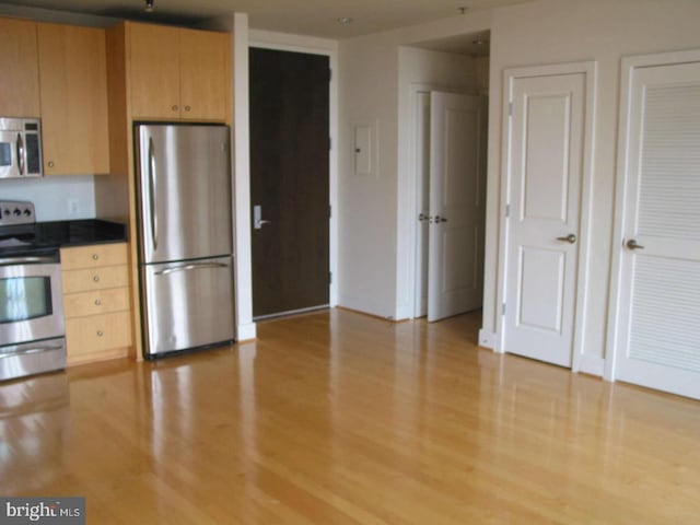 kitchen featuring appliances with stainless steel finishes, light hardwood / wood-style floors, and light brown cabinets