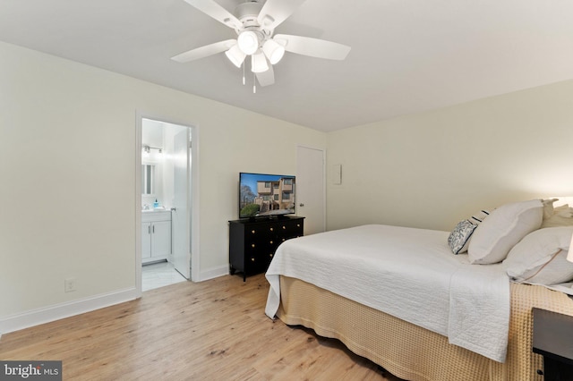 bedroom featuring ensuite bath, ceiling fan, and light wood-type flooring