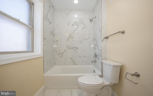 bathroom with tiled shower / bath combo and toilet