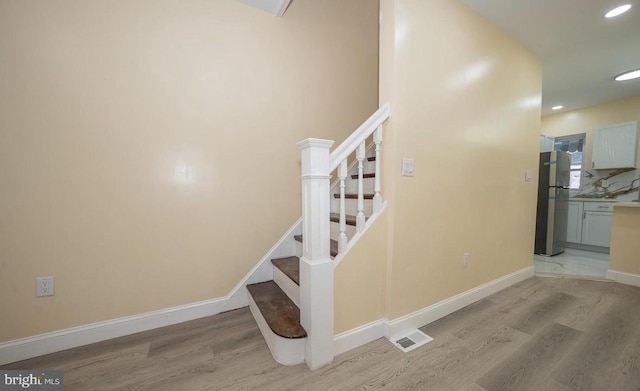 stairway with hardwood / wood-style floors