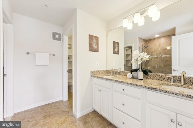 bathroom with vanity, a shower with door, and toilet