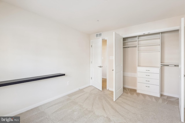 unfurnished bedroom featuring light colored carpet and a closet