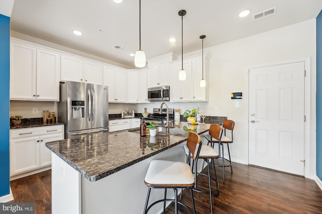 kitchen featuring appliances with stainless steel finishes, decorative light fixtures, white cabinetry, sink, and dark wood-type flooring