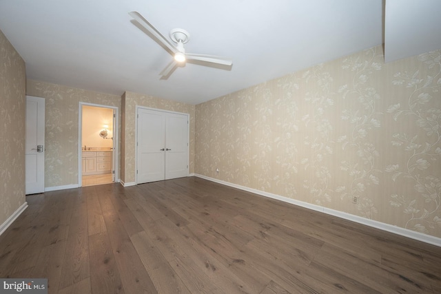 unfurnished bedroom with dark wood-type flooring, connected bathroom, ceiling fan, and a closet