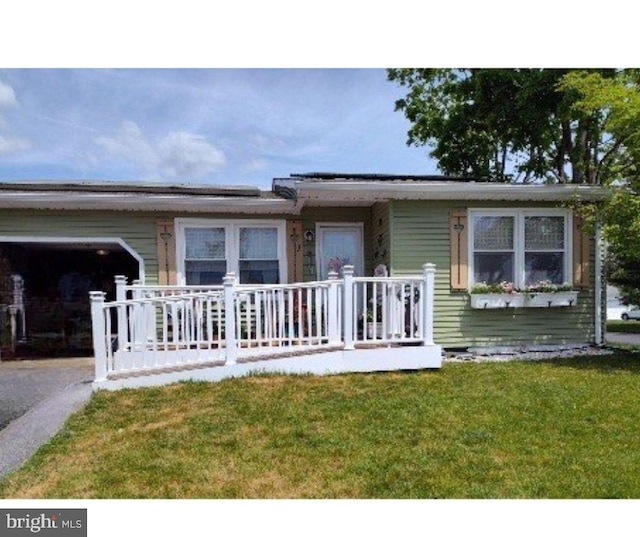 view of front of home featuring a garage, a front yard, and driveway