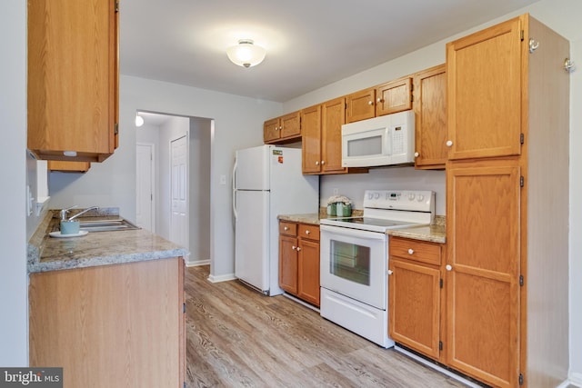 kitchen featuring sink, white appliances, and light hardwood / wood-style floors