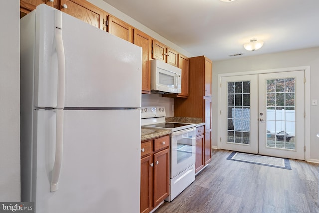 kitchen featuring dark hardwood / wood-style flooring, white appliances, and french doors