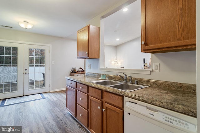 kitchen with dishwasher, sink, dark hardwood / wood-style floors, and french doors