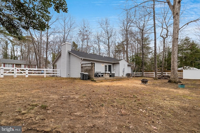 rear view of property with an outdoor fire pit