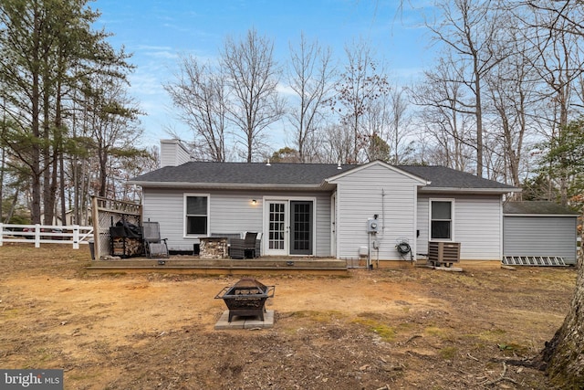 back of property featuring a fire pit and a deck