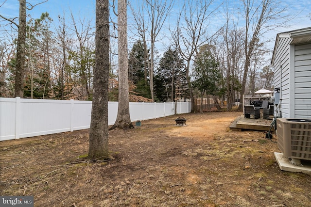 view of yard with a wooden deck, an outdoor fire pit, and cooling unit