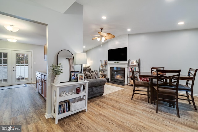 living room with vaulted ceiling, ceiling fan, light wood-type flooring, and french doors