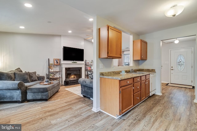 kitchen featuring lofted ceiling, sink, light hardwood / wood-style floors, and dishwasher