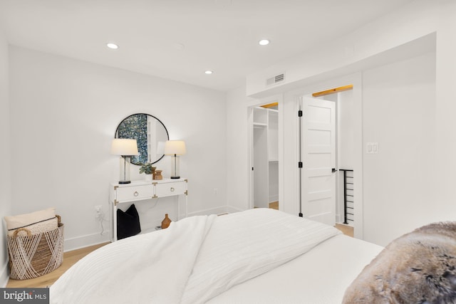 bedroom featuring hardwood / wood-style flooring, a spacious closet, and a closet