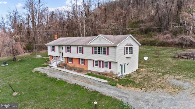 view of front of house featuring a chimney and a front yard