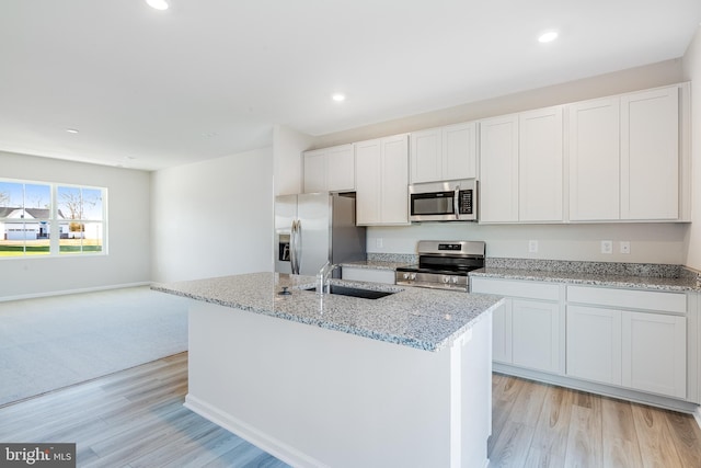 kitchen featuring an island with sink, appliances with stainless steel finishes, sink, and white cabinets