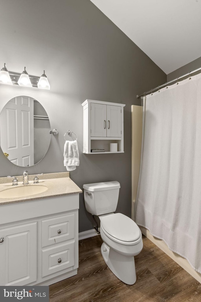 full bathroom featuring vaulted ceiling, wood-type flooring, vanity, toilet, and shower / bath combo with shower curtain