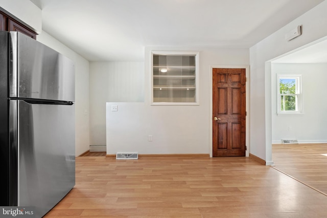 kitchen featuring stainless steel fridge and light hardwood / wood-style flooring