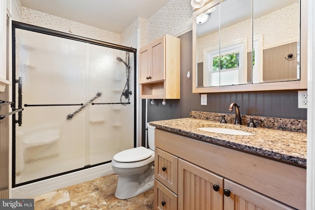 bathroom with an enclosed shower, vanity, and toilet