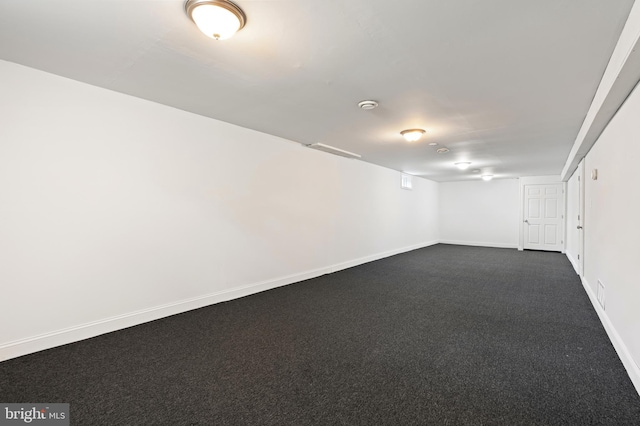 basement featuring dark carpet