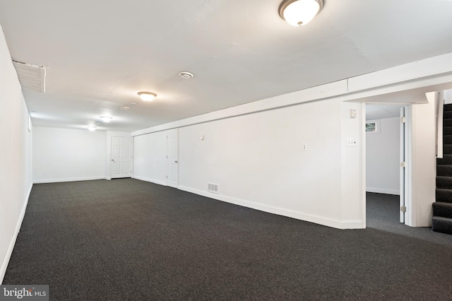 basement featuring dark carpet