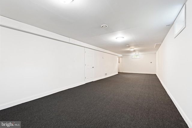 basement featuring dark colored carpet