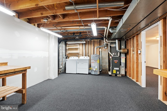 basement with water heater, dark colored carpet, washer and dryer, and heating unit