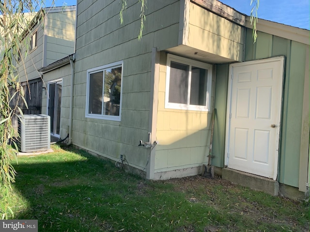 view of home's exterior with cooling unit and a yard