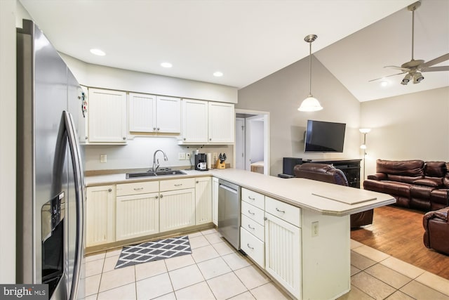 kitchen featuring light tile patterned flooring, appliances with stainless steel finishes, sink, hanging light fixtures, and kitchen peninsula