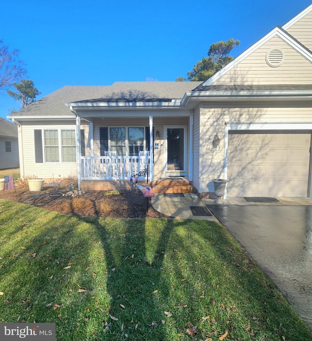 view of front facade with a garage, a front yard, and covered porch