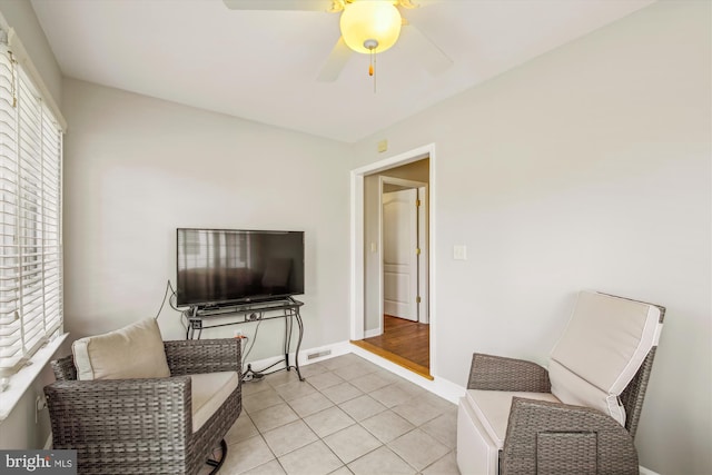 living area featuring ceiling fan and light tile patterned floors