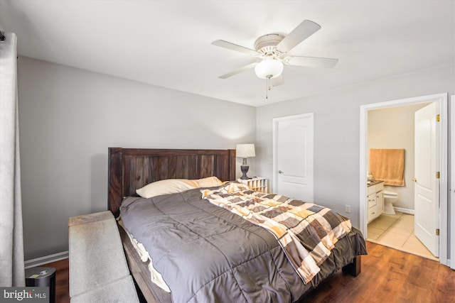 bedroom with ensuite bath, light hardwood / wood-style flooring, and ceiling fan